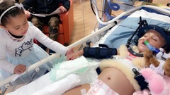Two-year-old Amirah Najim-Phillips in Starship ICU, holding hands with her elder sister Zahara. Photo / Supplied