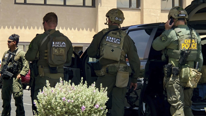 Law enforcement agencies descend on the scene of the crime. (Photo / AP)