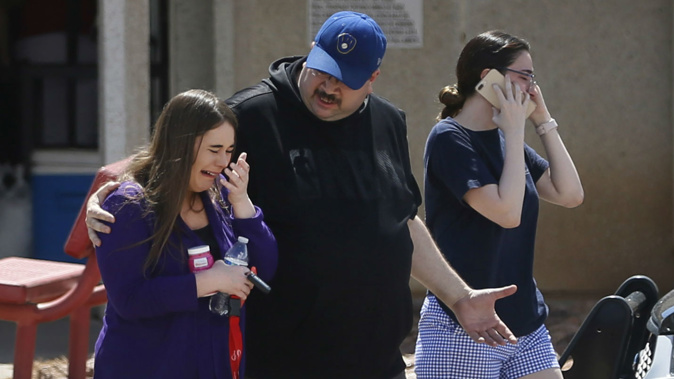 People arrive at MacArthur Elementary looking for family and friends as the school is being used a re-unification centre during the aftermath of a shooting at the Walmart. (Photo / AP)