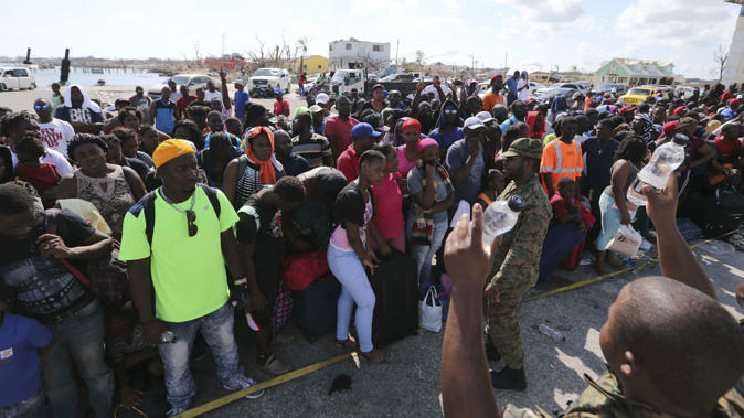 Residents queue up to catch a ferry so they can evacuate. (Photo / AP)