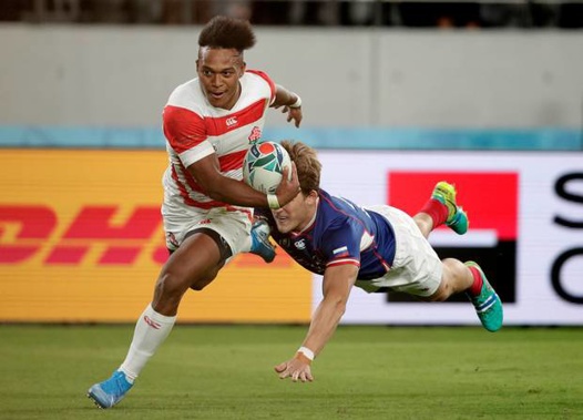 Japan's Kotaro Matsushima, left, fends off Russia's Vladislav Sozonov to score his third try. (Photo / AP)