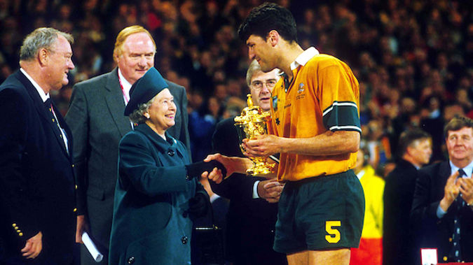 Australian captain John Eales is presented the William Webb Ellis Trophy by Queen Elizabeth II after winning the Rugby World Cup Final against France, November 6 1999, Cardiff, Wales. Australia won the match 35 - 12. (Photo: PHOTOSPORT)
