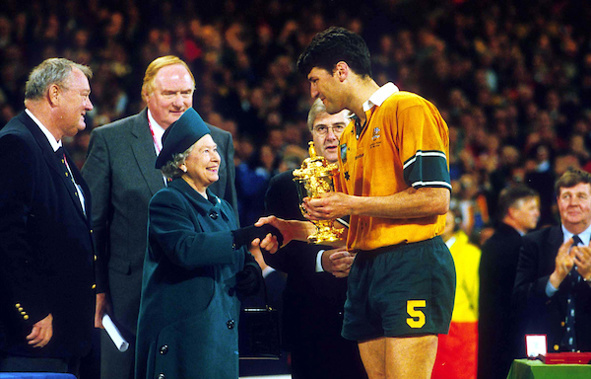 Australian captain John Eales is presented the William Webb Ellis Trophy by Queen Elizabeth II after winning the Rugby World Cup Final against France, November 6 1999, Cardiff, Wales. Australia won the match 35 - 12. (Photo: PHOTOSPORT)