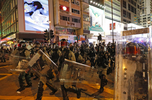Riot policemen march on a street in Hong Kong. (Photo / Ap)