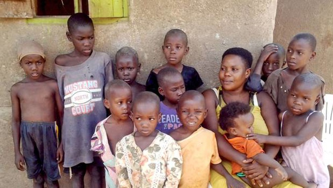 Mariam Nabatanzi sits in front of the house with twelve of her children in Kasawo, Uganda, 28 April 2017. (Photo / Getty)