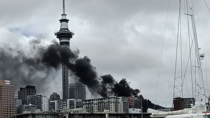 Thick black smoke pours from the scene on Hobson St this afternoon. (Photo / Michael Richards)