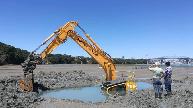 A digger that was rescuing a car stuck on Auckland beach has ended up being left stranded for three days when it got stuck as well. Photo / Jason Littin