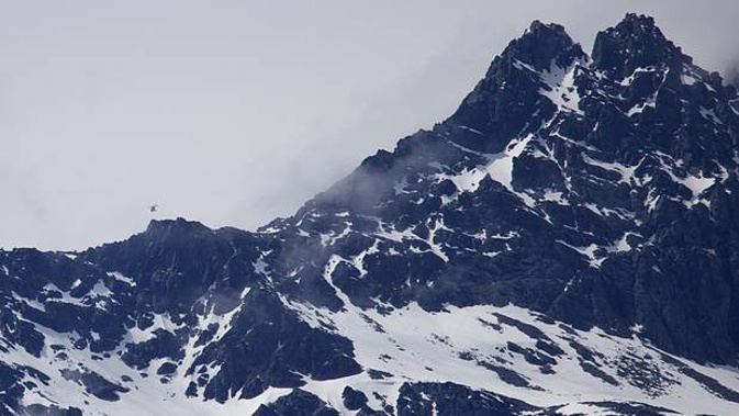 A rescue helicopter passing close to Double Cone in the Remarkables after two people reportedly got in trouble in the area. Photo / James Allan