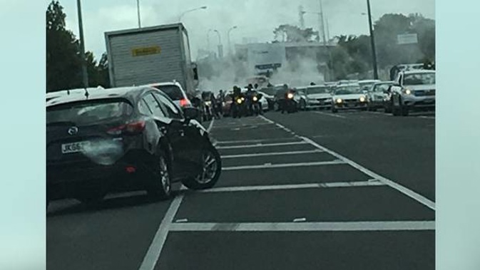 In a photo the members can be seen blocking the road as a car does a burnout behind them. Photo / Supplied