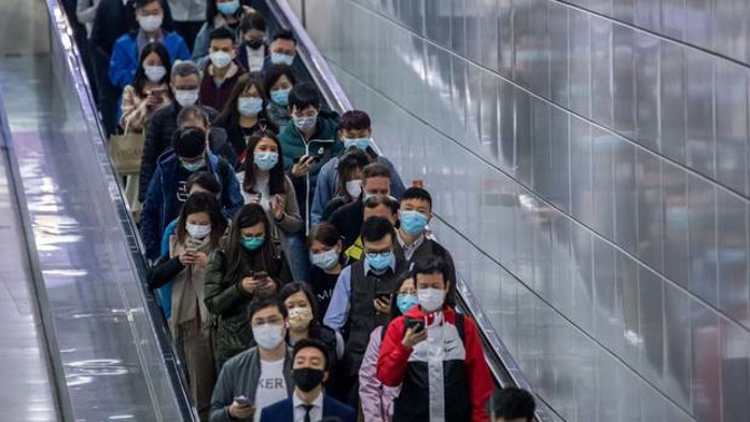People wearing protective masks walk at Hong Kong Station of MTR in Hong Kong. Photo / Bloomberg