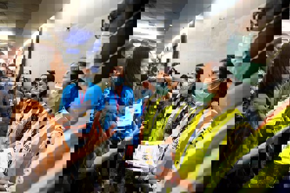 Prime Minister Jacinda Ardren speaks to masked health officials in the customs hall at Auckland International Airport. Photo / File
