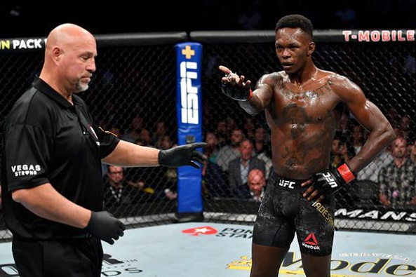 Israel Adesanya reacts after accidentally poking the eye of Yoel Romero. Photo / Getty