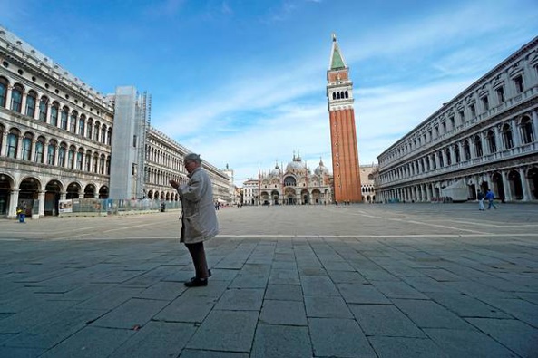 A woman walks in a deserted St. Mark's Square in Venice, Italy, where widespread lock-downs are now in place. Photo / AP