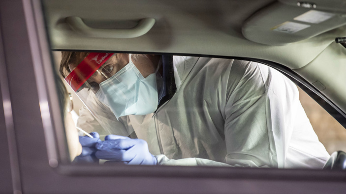 Clinical staff workers conduct a drive-thru COVID-19 test. (Photo / AP)