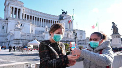 Women wearing face mask disinfect their hands in central Piazza Venezia, in Rome, Sunday, March 8. Photo / AP