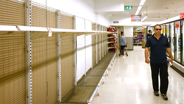 Empty supermarket shelves stripped bare by panic buyers.