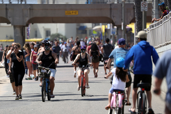 People ride and walk on a path along beach amid the coronavirus pandemic on May 15, 2020 in Huntington Beach, California. (Photo / Getty)