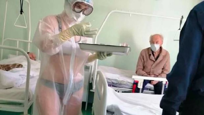 A nurse on an all-male coronavirus ward in Russia has been disciplined after a picture of her wearing only underwear beneath a transparent PPE gown went viral. Photo / Tulskie Novosti