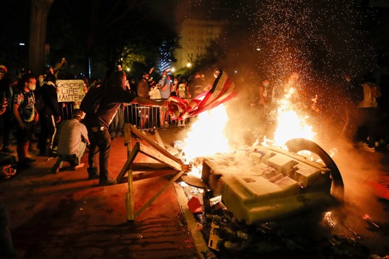 Demonstrators start a fire as they protest against the death of George Floyd near the White House in Washington. Photo / AP