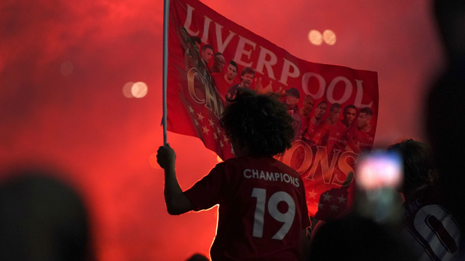 Liverpool supporters celebrate as they gather outside of Anfield Stadium. (Photo / AP)