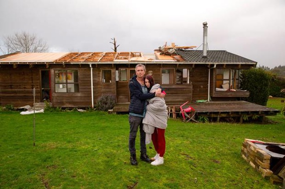 Dan Tudman and his daughter Eden support each other as they return to their family's Dairy Flat home which was badly damaged by Friday's tornado. New Zealand Herald photograph / Slyvie Whinray