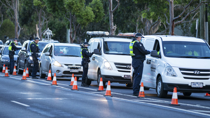 Police inspect individual drivers licenses and question drivers at a suburban roadblock site in Broadmeadows, in Melbourne,