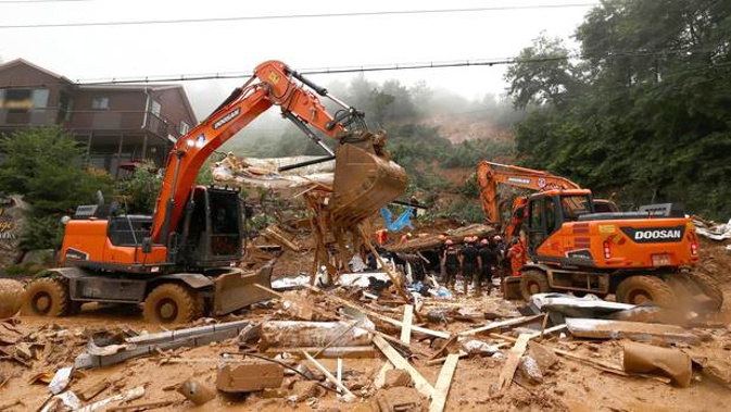 Rescue workers search for survivors at a damaged house after a landslide caused by heavy rain in Gapyeong, South Korea. (Photo / AP)