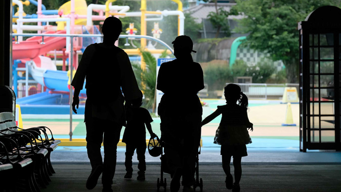 Parents and children enter a swimming pool open to a limited number of visitors as a preventive measure against coronavirus at Tokyo's Toshimaen amusement park on July 13.