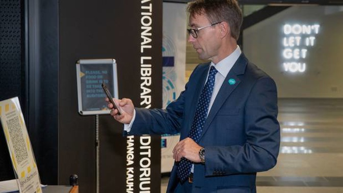 Director general of health Dr Ashley Bloomfield scanning the government's QR code. Photo / Mark Mitchell