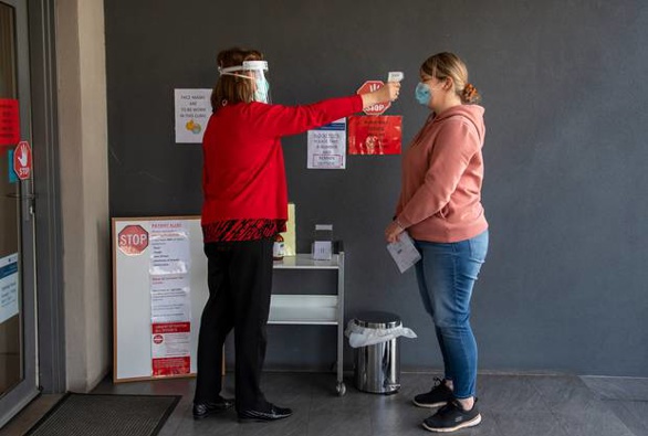 A patient has her temperature checked at a Melbourne medical clinic during lockdown due to the continuing spread of the coronavirus in Victoria. Photo / AP