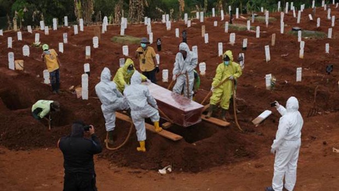 Local authorities in Indonesia ordered eight people who broke the country's face mask laws to dig graves for Covid-19 victims. Photo / Getty Images