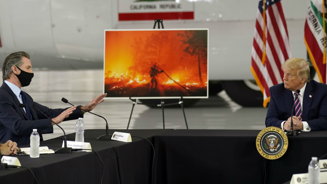 President Donald Trump listens as California Gov. Gavin Newsom speaks during a briefing at Sacramento McClellan Airport on the western wildfires. (Photo / AP)