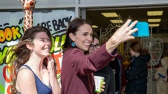Prime Minister Jacinda Ardern posing for selfies with fans during her walkabout in Palmerston North. Photo / Mark Mitchell