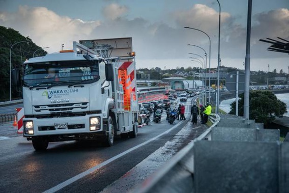 This photo shows the front of the queue at the foot of the harbour bridge after it was closed. Motorcyclists rest against the barrier. (Photo / Antony Gray)