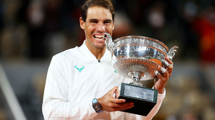 Rafael Nadal bites the winning trophy after claiming the French Open title for the 13th time  time with a straight sets victory over Novak Djokovic.