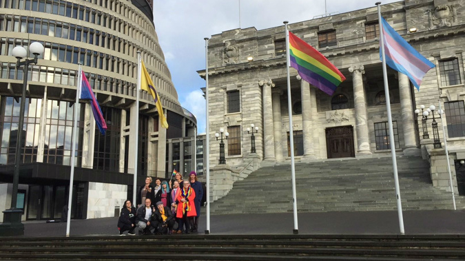 Flags representing the Rainbow Community flying outside Parliament. 