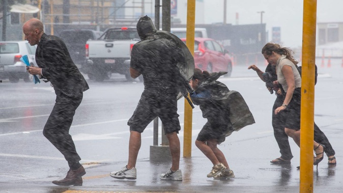 Pedestrians battle wild weather delivered with the remnants of Cyclone Fehi in February 2018. That cyclone season is being compared to the coming one. Photo / Mark Mitchell