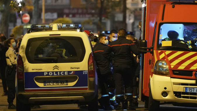 Police officers and rescue workers block the access to the scene after a Greek Orthodox priest was shot. (Photo / AP)
