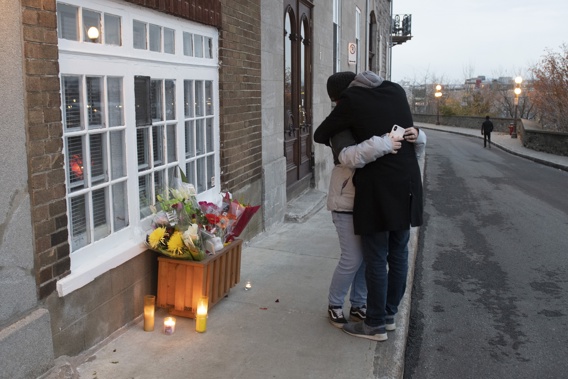 Two mourners lay flowers outside a victims house in Quebec City. Photo / AP