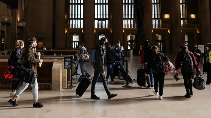 Travelers wait in line to board a train at the 30th Street Station ahead of the Thanksgiving holiday in Philadelphia. (Photo / AP)