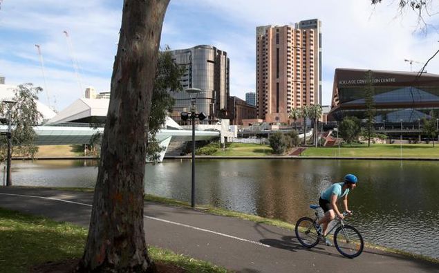 A man cycles along the Torrens River in Adelaide after the strict lockdown measures eased. (Photo / Getty)