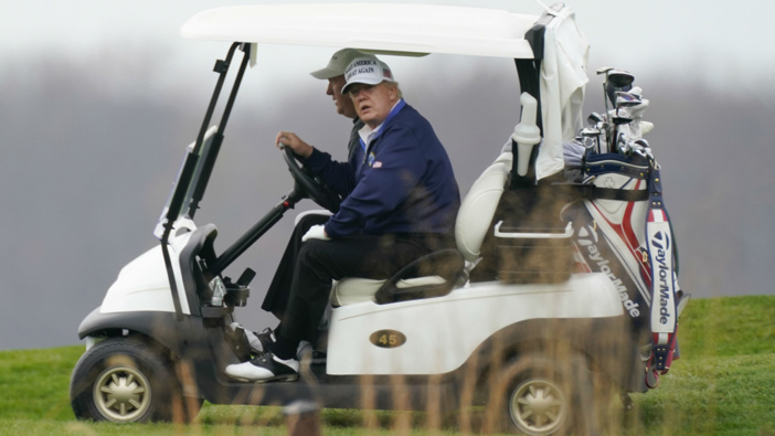 Donald Trump drives a golf cart as he golfs at Trump National Golf Club. (Photo / AP)