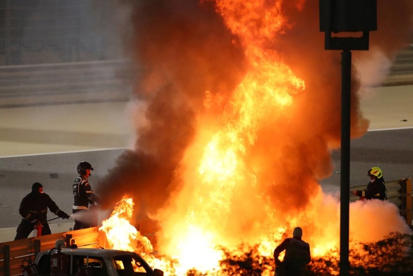 Staff extinguish flames from Haas driver Romain Grosjean's car during the Formula One race in Bahrain. Photo / AP