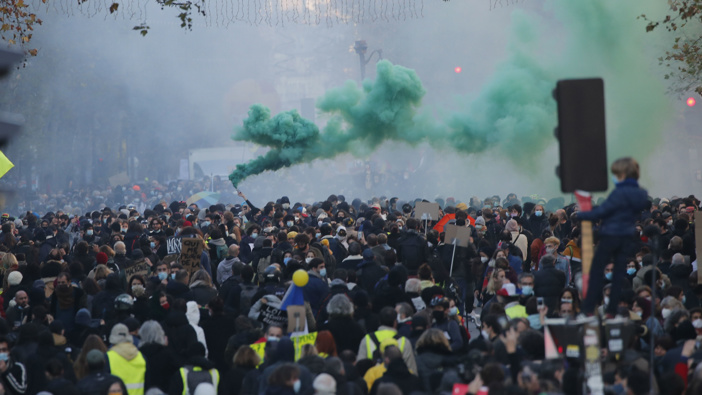 Protesters march during a demonstration against a security law that would restrict sharing images of police