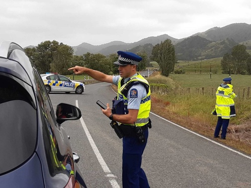 Police stop traffic after a serious shooting incident near Tangowahine on State Highway 14 in Northland. Photo / Tania Whyte