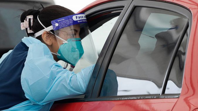 A man receives a Covid-19 test at a drive-thru testing station at a beach in Sydney. Photo / AP