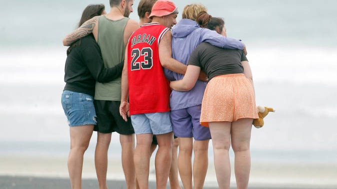 People pay their respects at Bowentown Beach after a fatal shark attack. Photo / George Novak