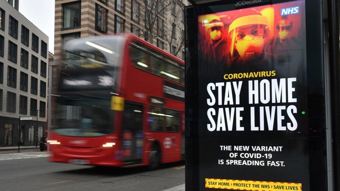 A London Transport famous red bus London passing a Covid-19 sign during England's third national lockdown to curb the spread of coronavirus in London. (Photo / AP)
