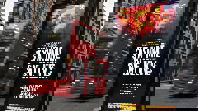 A London Transport famous red bus London passing a Covid-19 sign during England's third national lockdown to curb the spread of coronavirus in London. (Photo / AP)