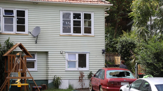 Drive-by shooting at house on McCullough Ave, Mt Roskill - bullet holes marked by tape on windows and shotgun damage to car. Photo / Hayden Woodward